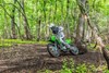 Three-quarter front angle of a person riding a motorcycle off-road.
