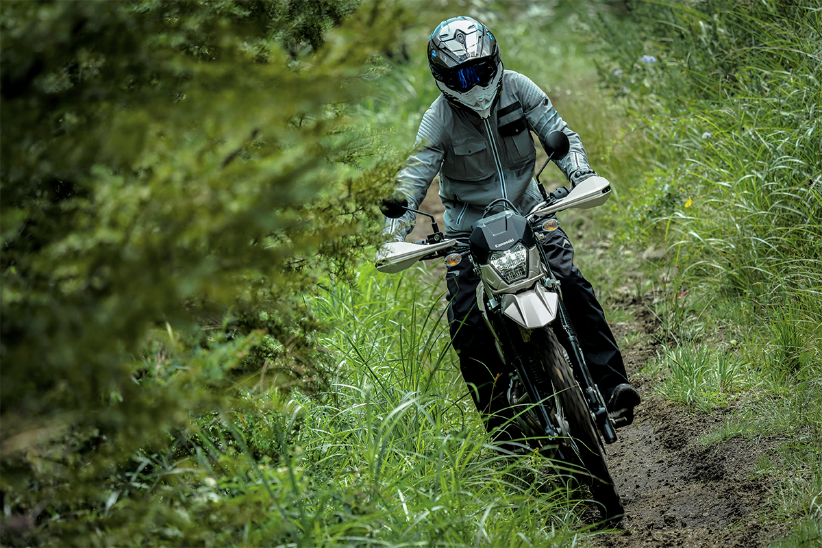 Front angle of a person riding a motorcycle off-road on a trail.