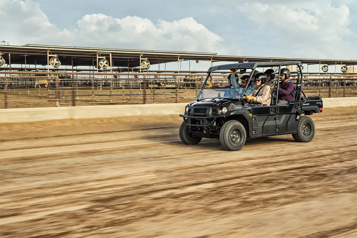 Three-quarter front angle of six people riding in a side x side at a jobsite.
