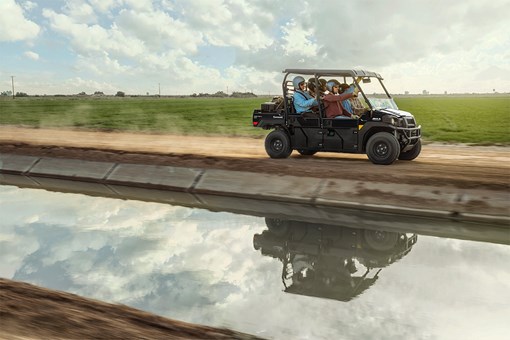 Side angle of six people riding in a side x side at a jobsite. opens in a new window