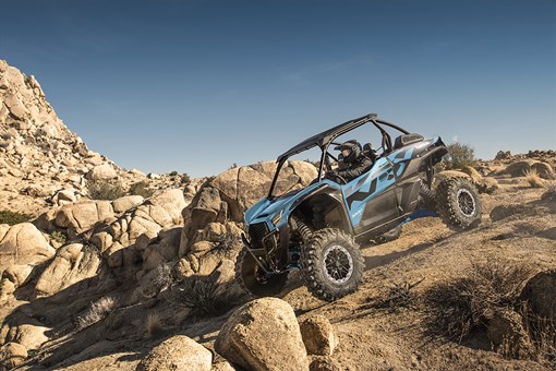 Side angle of a person riding a side x side off-road. opens in a new window