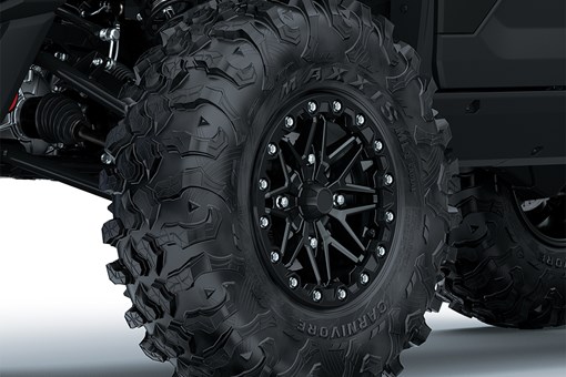 Close-up view of the front-left tire of a side x side staged in a white studio background. opens in a new window