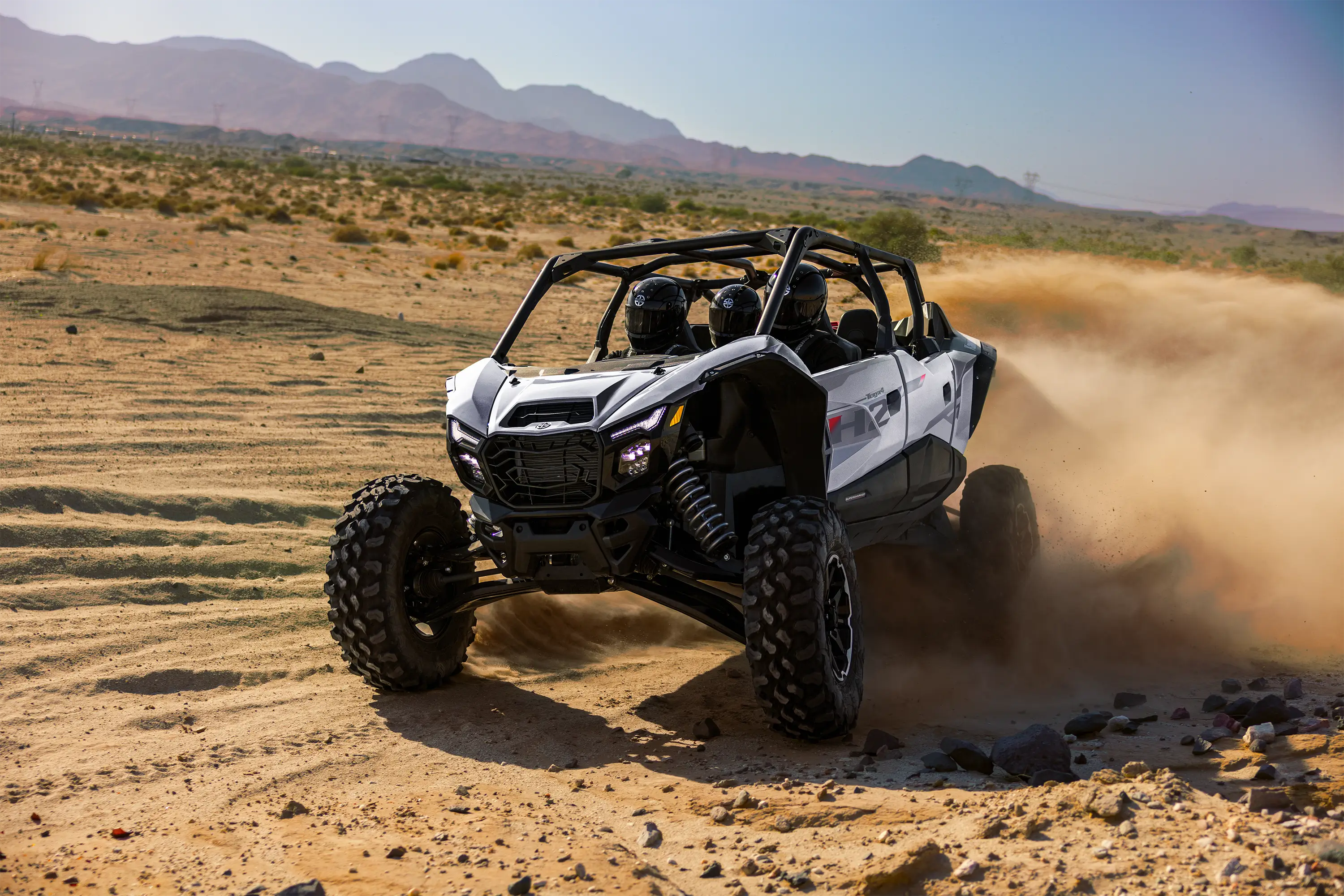 Front angle of a person driving a side x side in a desert.