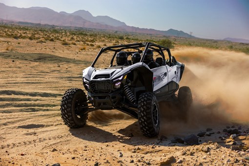 Front angle of a person driving a side x side in a desert. opens in a new window