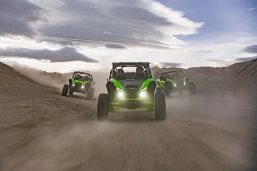 Front angle of 3 side x sides driving off-road. opens in a new window