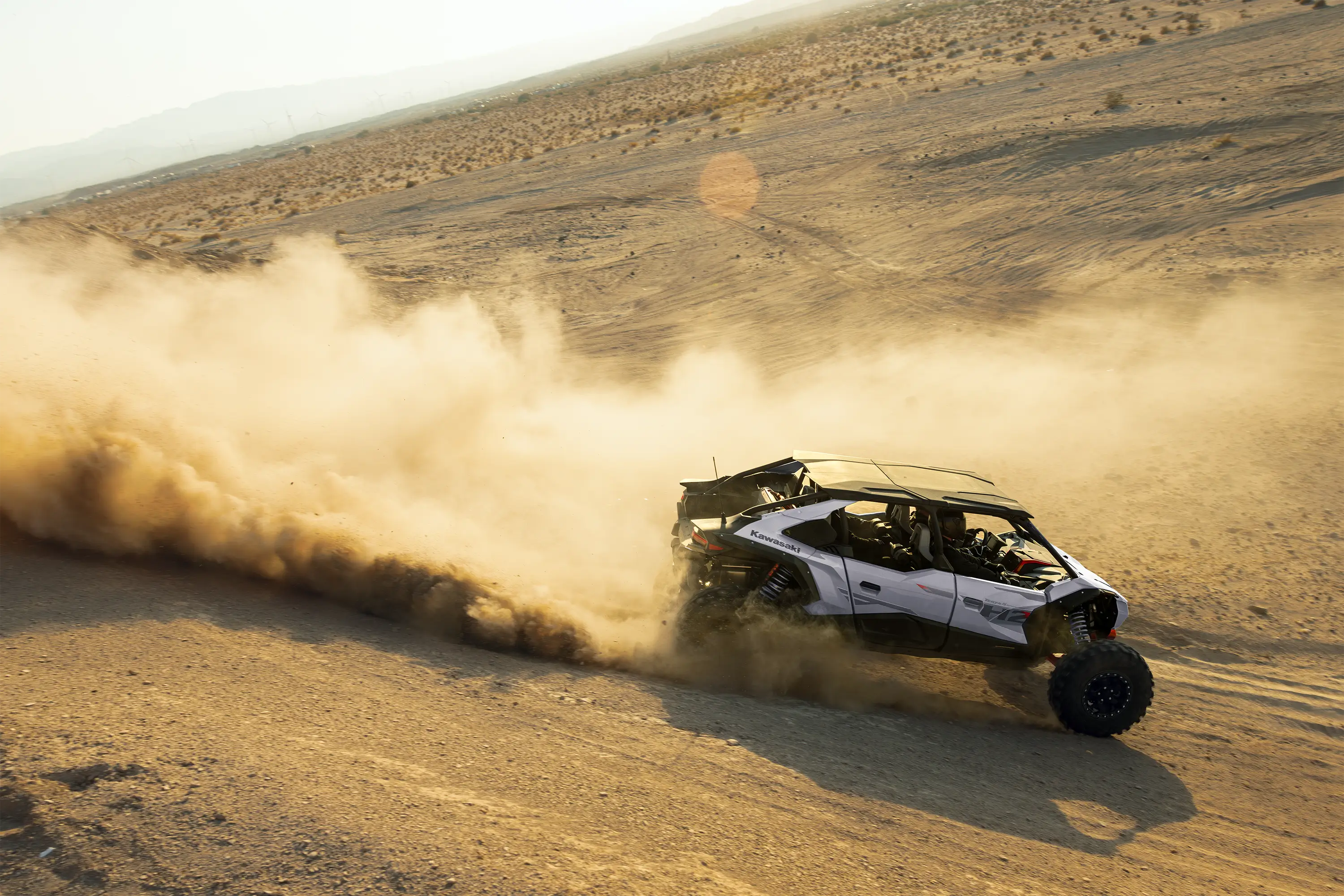 Side angle of a person driving a side x side in a desert.