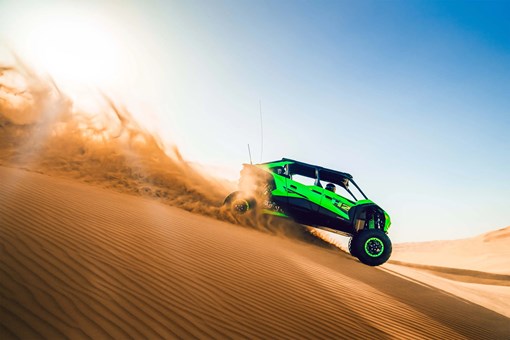 Side angle of a person driving a side x side down hill off-road. opens in a new window