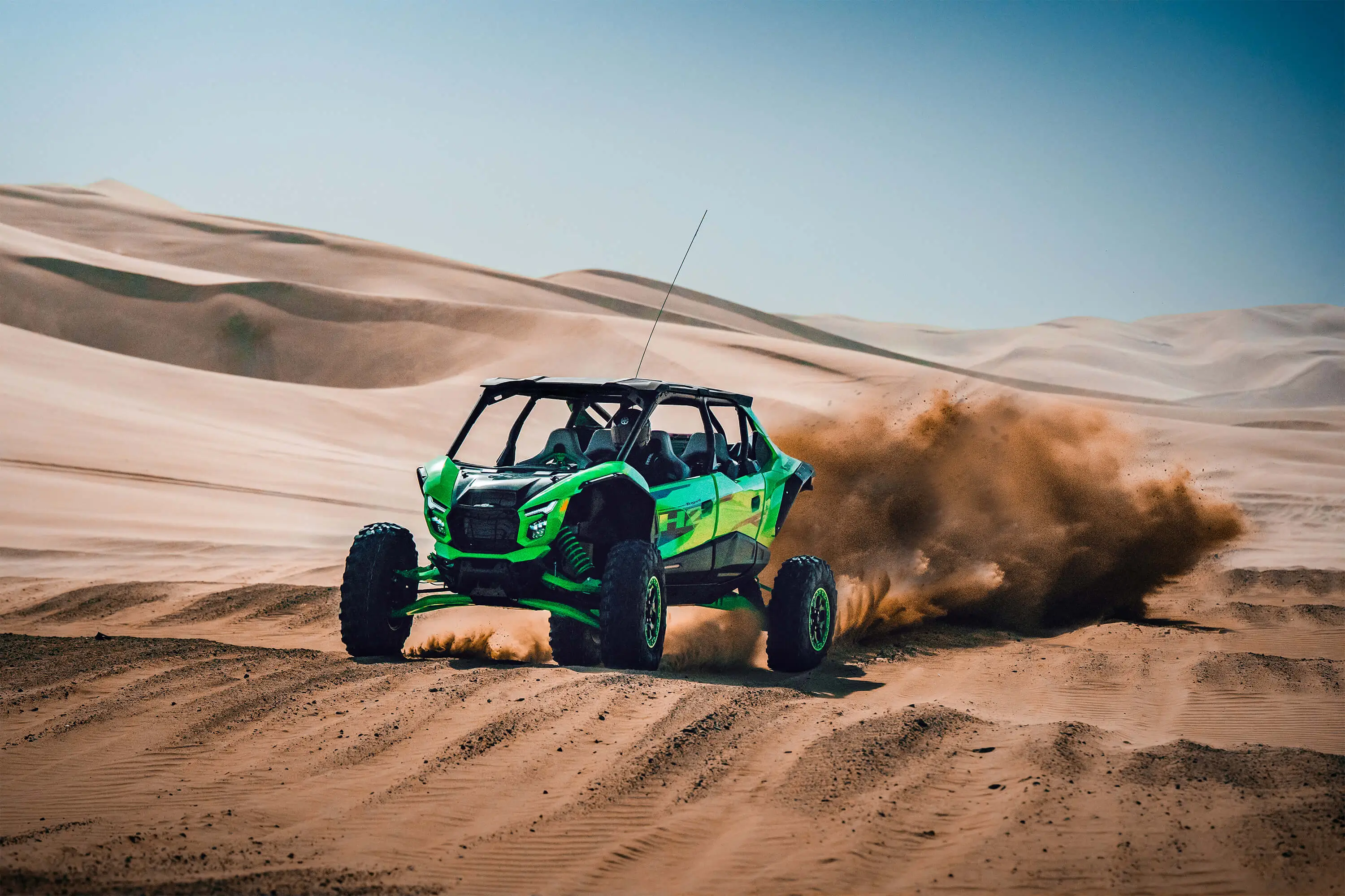 Front angle of a person driving a side x side off-road over large whoops.