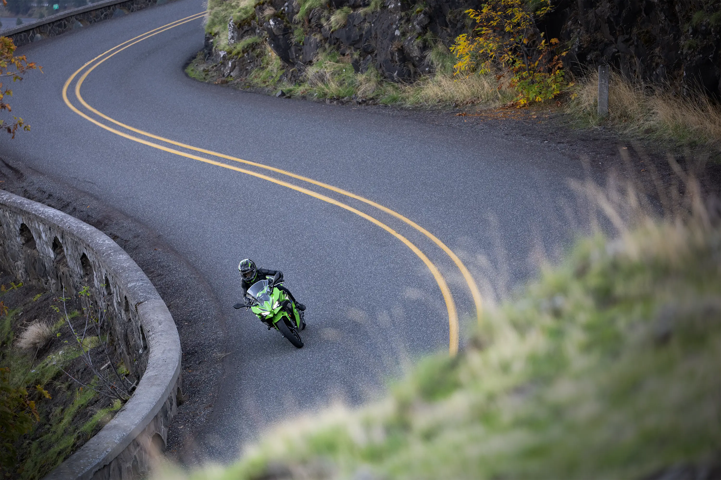 Aerial view of a person riding a motorcycle on a curvy road.