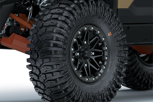 Close-up view of the front-left tire of a side x side staged in a white studio background. opens in a new window