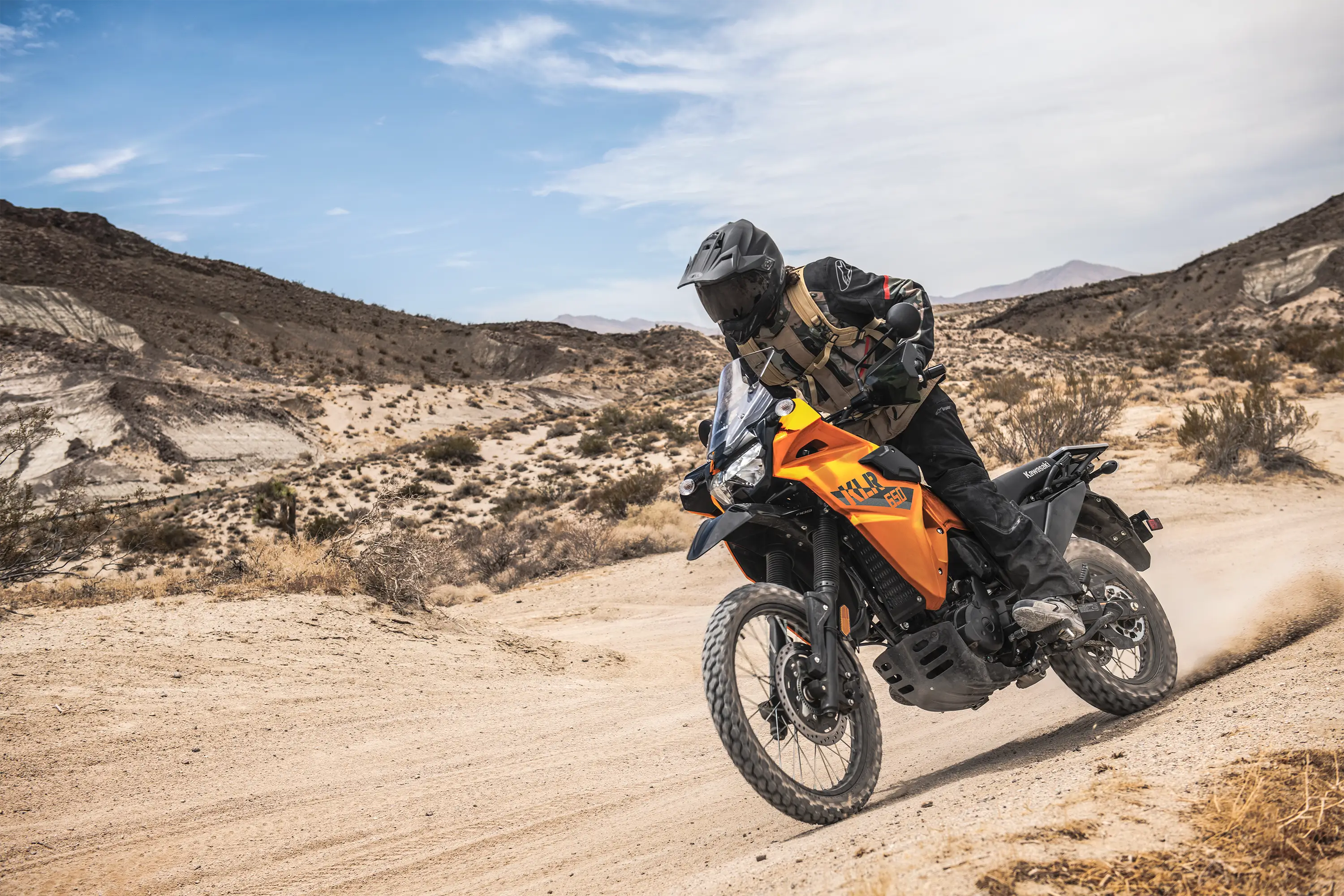 Three-quarter front angle of a person riding a motorcycle off-road.