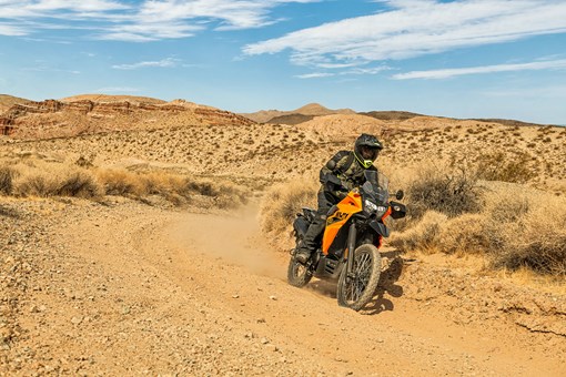 Three-quarter front angle of a person riding a motorcycle around a corner off-road. opens in a new window