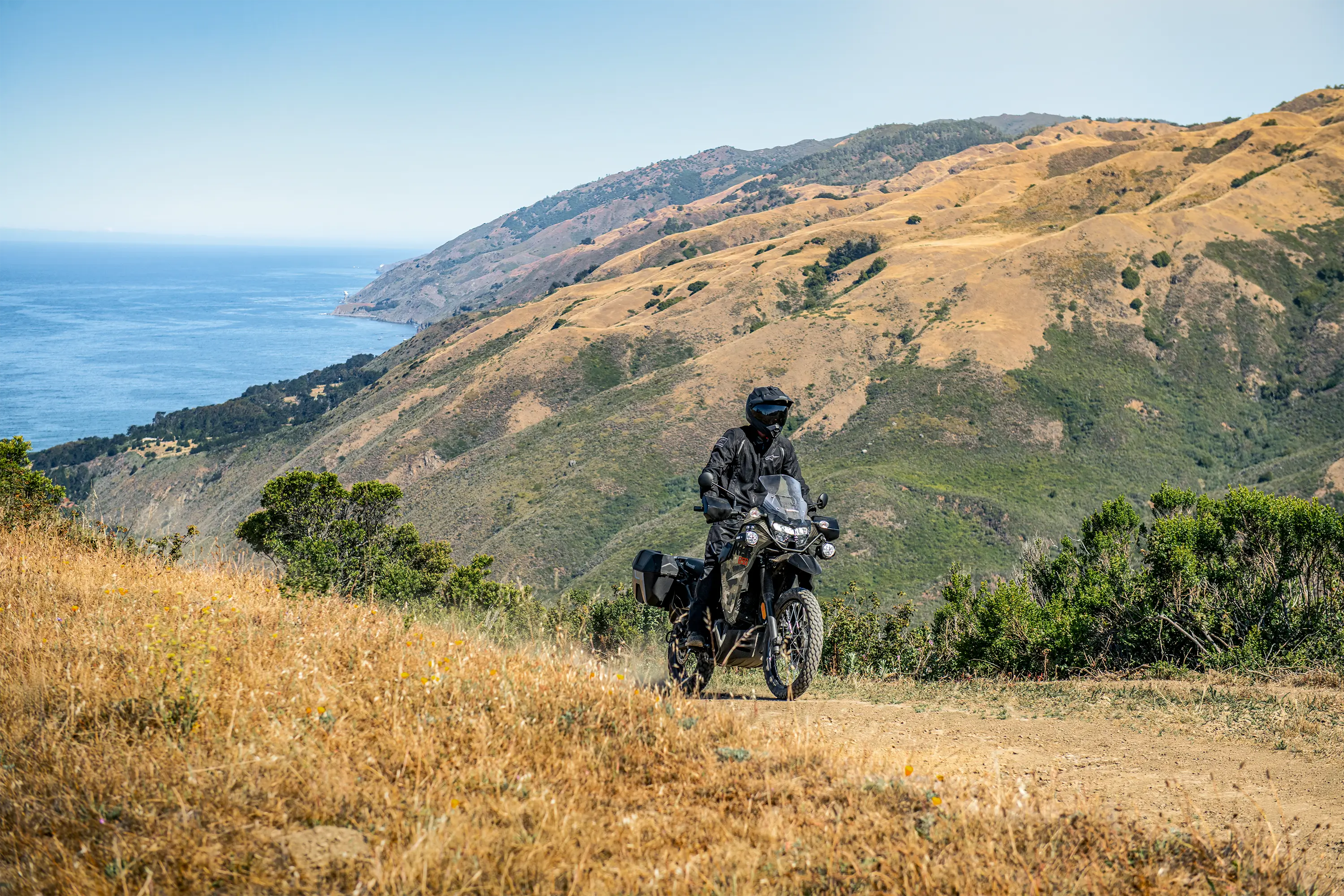 Side angle of a person riding a motorcycle off-road.