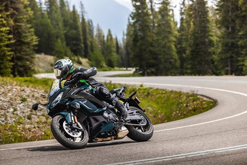 Three-quarter front angle of a person riding a motorcycle on a highway. opens in a new window