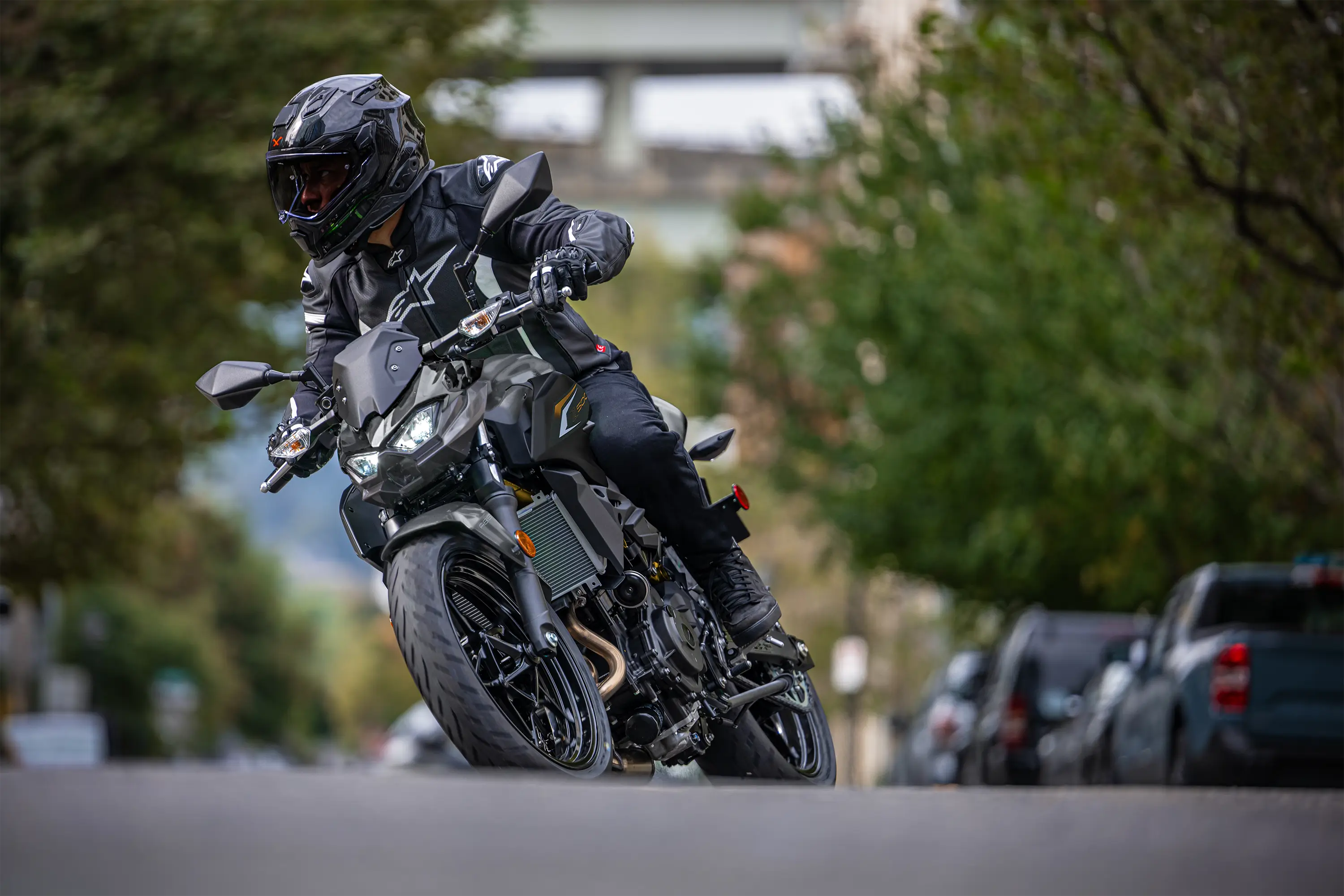 Front angle of a person riding a motorcycle on the street.