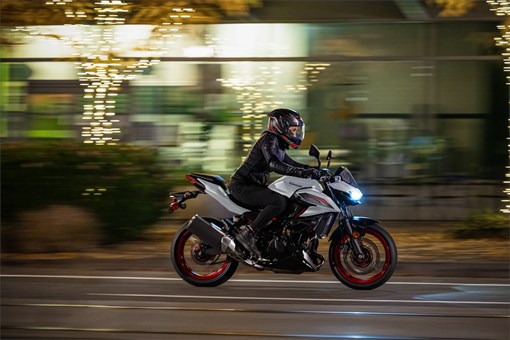 Side angle of a person riding a motorcycle on the street. opens in a new window
