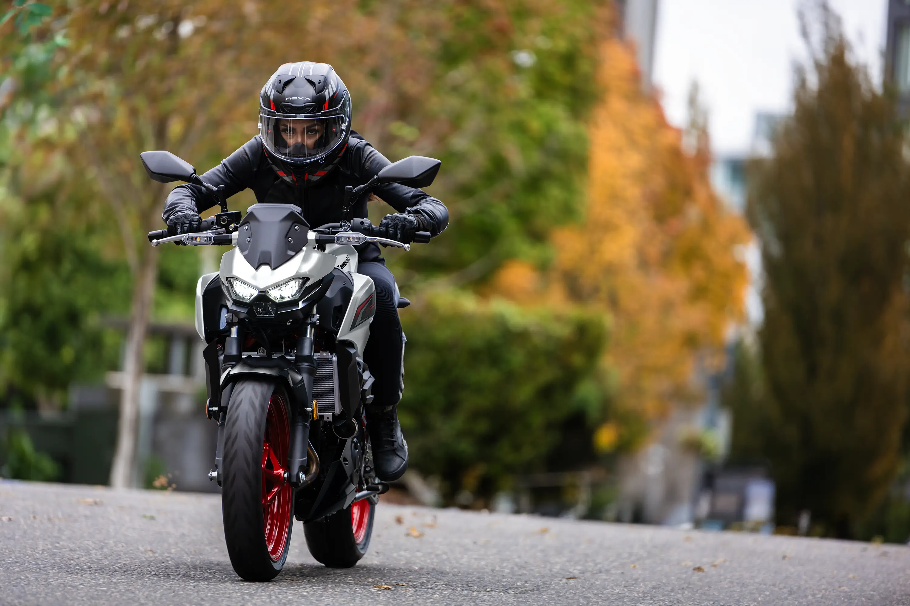 Front angle of a person riding a motorcycle on the street.