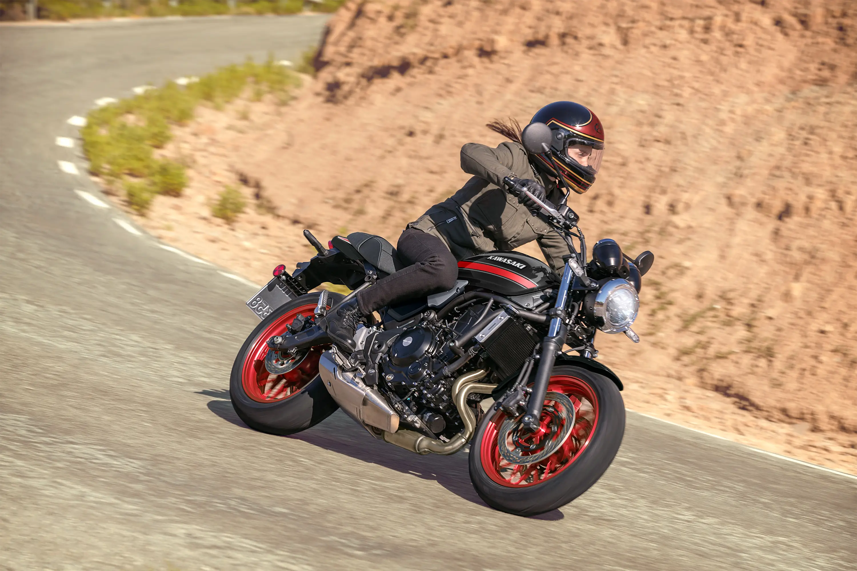 Three-quarter front angle of a person riding a motorcycle on a highway.