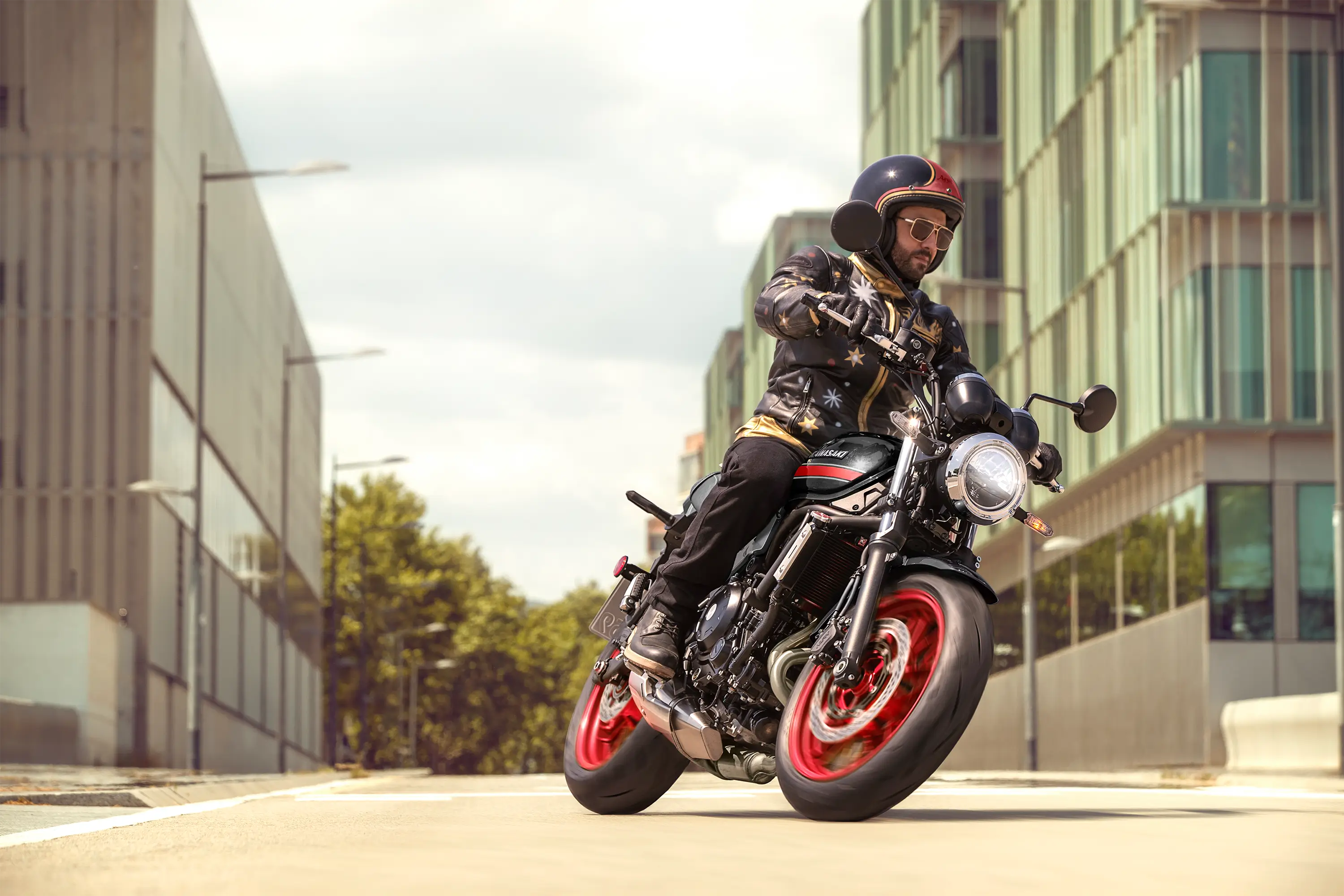 Three-quarter front angle of a person riding a motorcycle on the street.