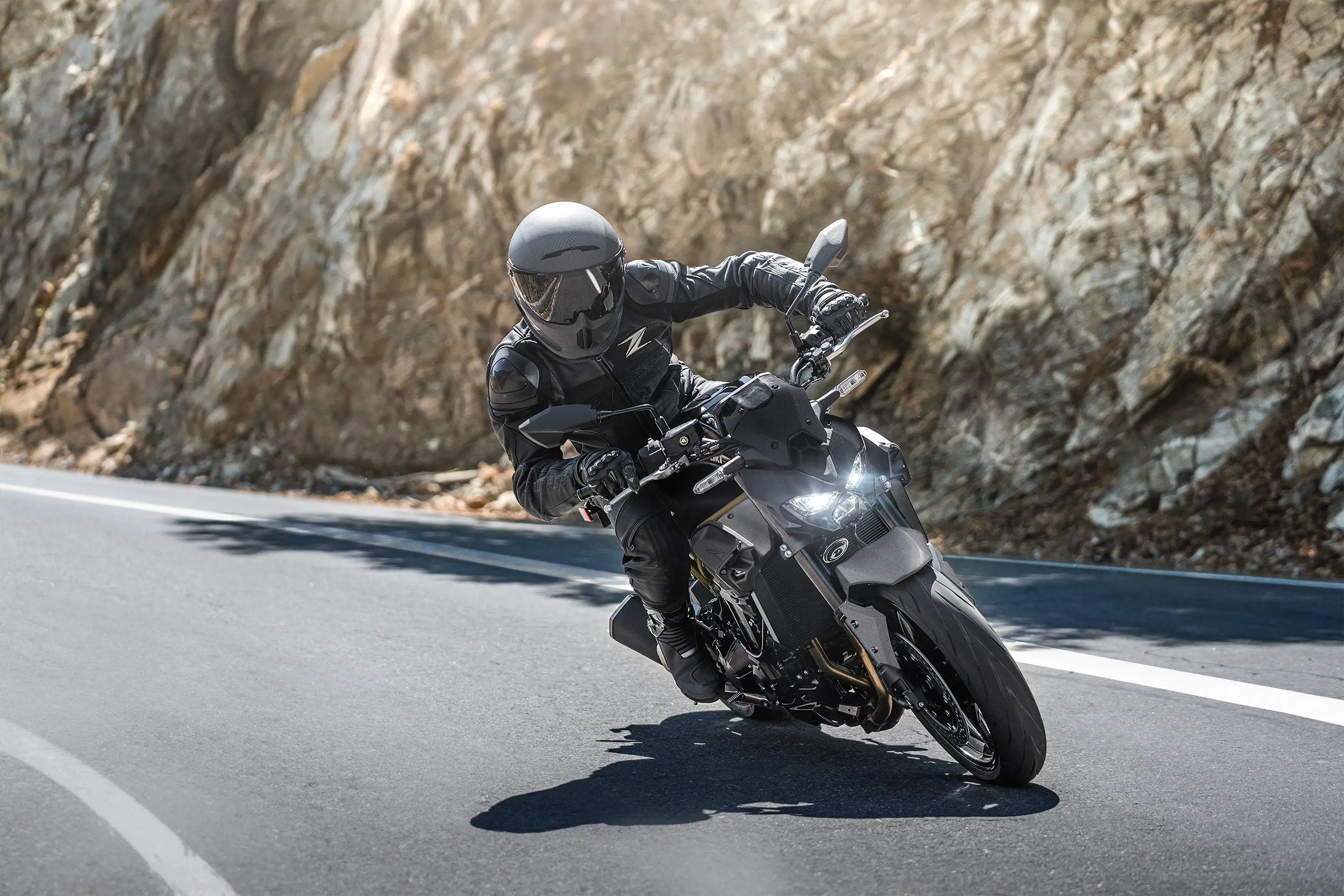 Three-quarter front angle of a person riding a motorcycle on a highway.