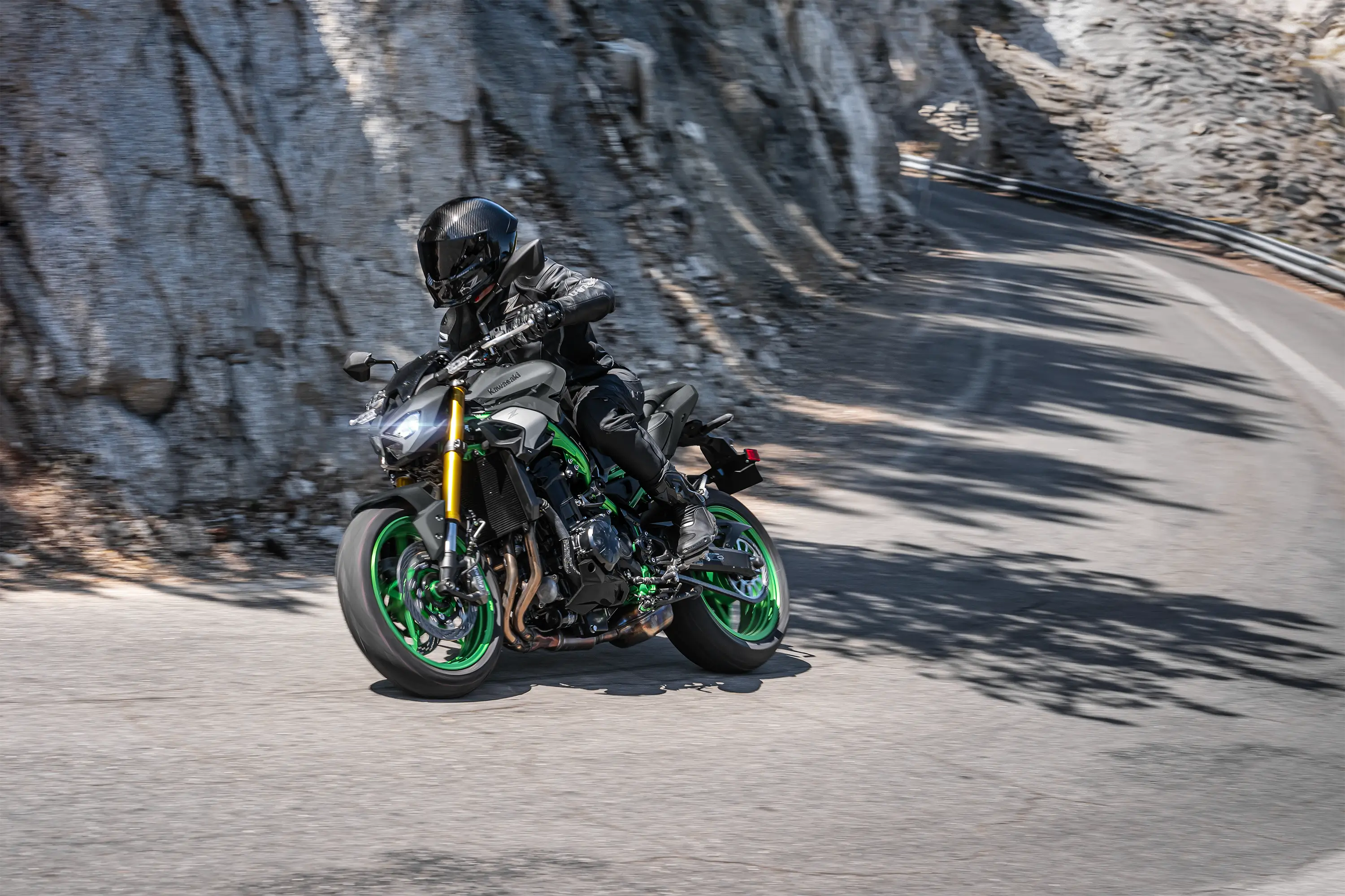 Three-quarter front angle of a person riding a motorcycle on a canyon.