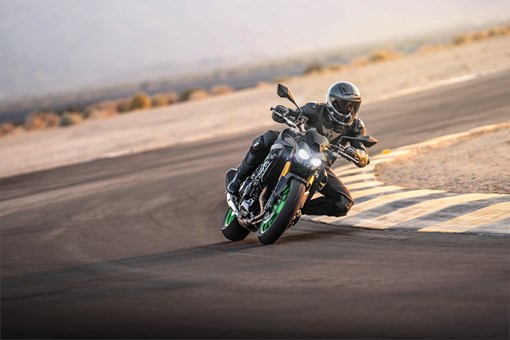 Three-quarter front angle of a person riding a motorcycle on a track. opens in a new window