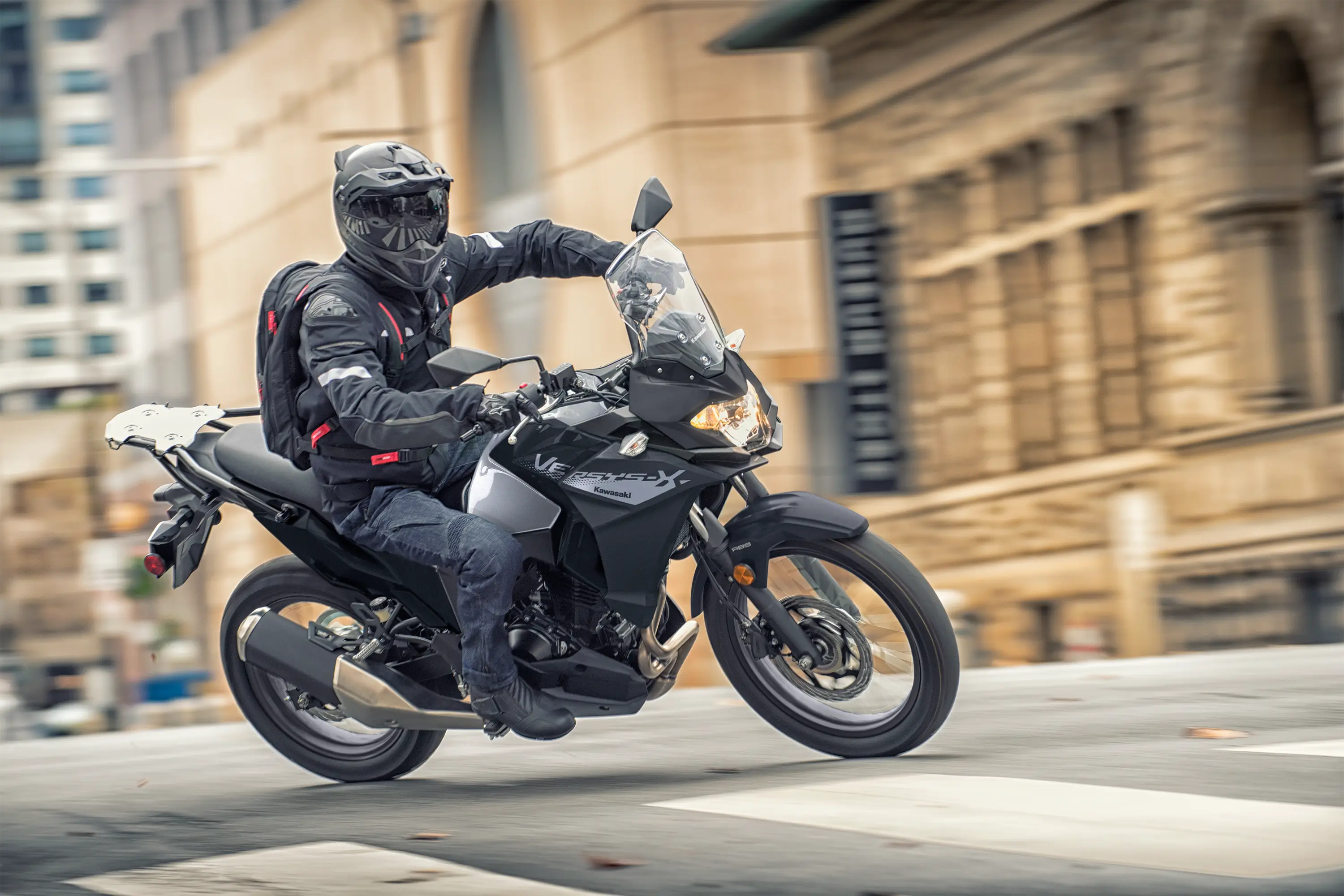 Three-quarter front angle of a person riding a motorcycle turning on the street.