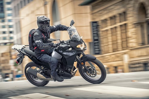Three-quarter front angle of a person riding a motorcycle turning on the street. opens in a new window