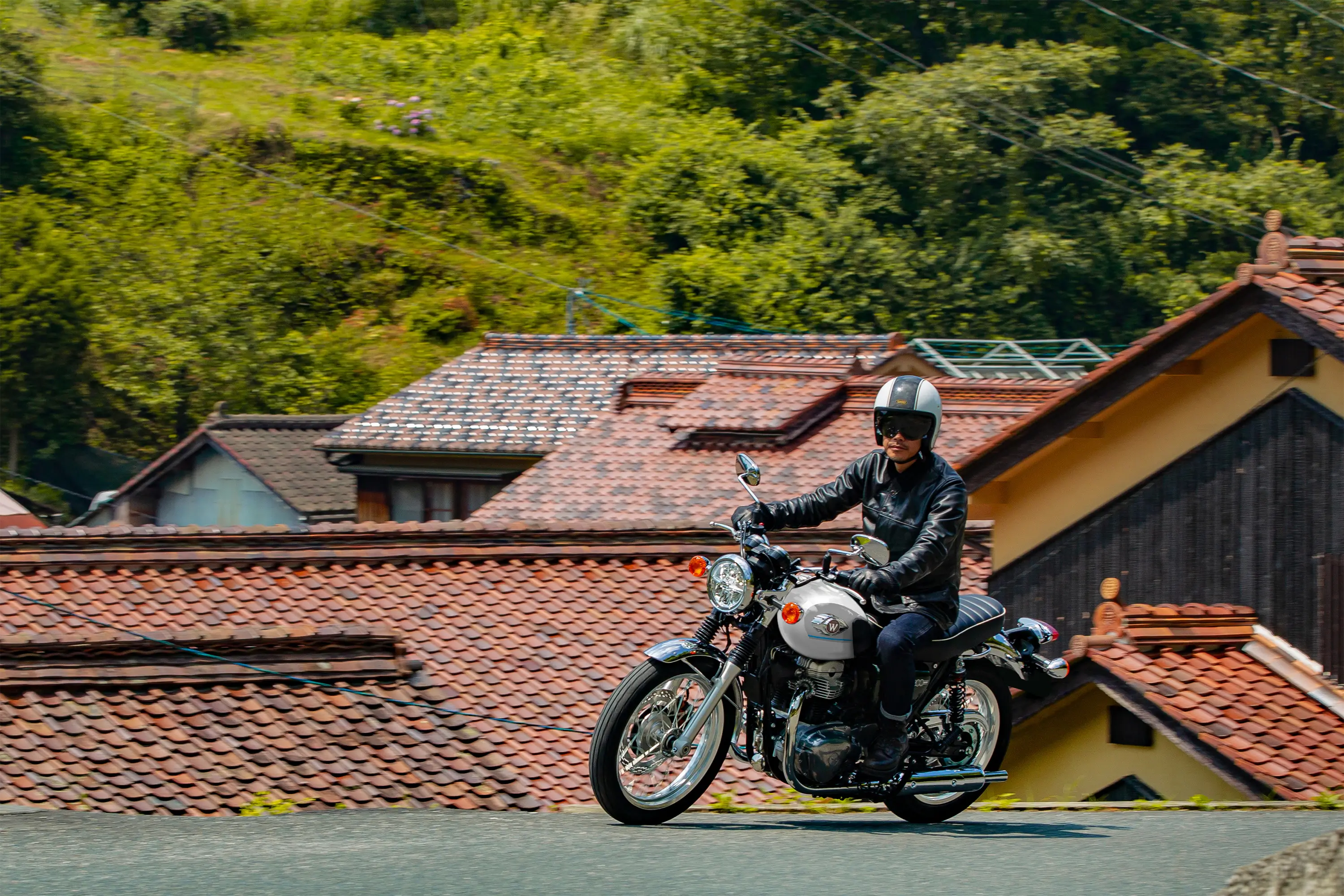 Side angle of a person riding a motorcycle on the street.