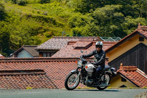 Side angle of a person riding a motorcycle on the street. opens in a new window