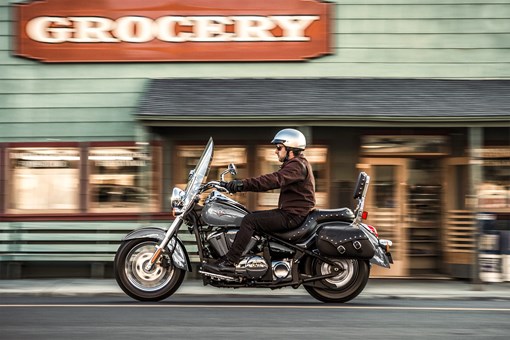 Side angle of a person riding a motorcycle on the street. opens in a new window