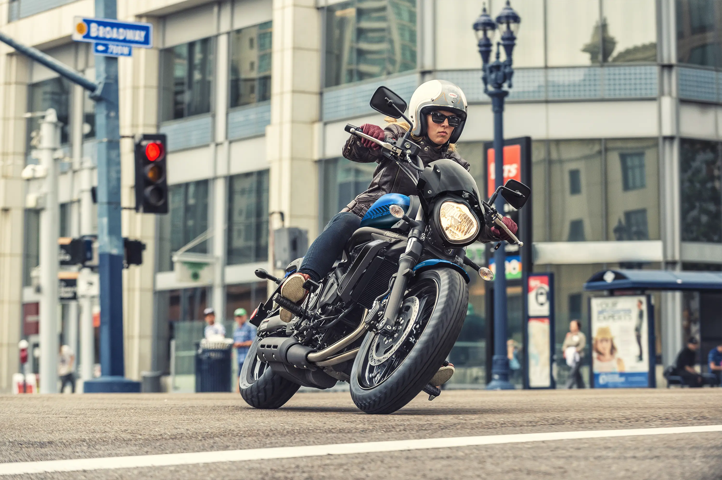 Front three-quarter angle of a person riding a motorcycle on the street.