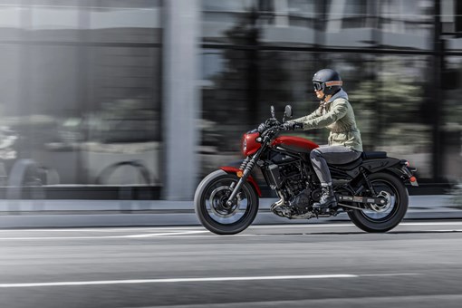 Side angle of a person riding a motorcycle on the street. opens in a new window