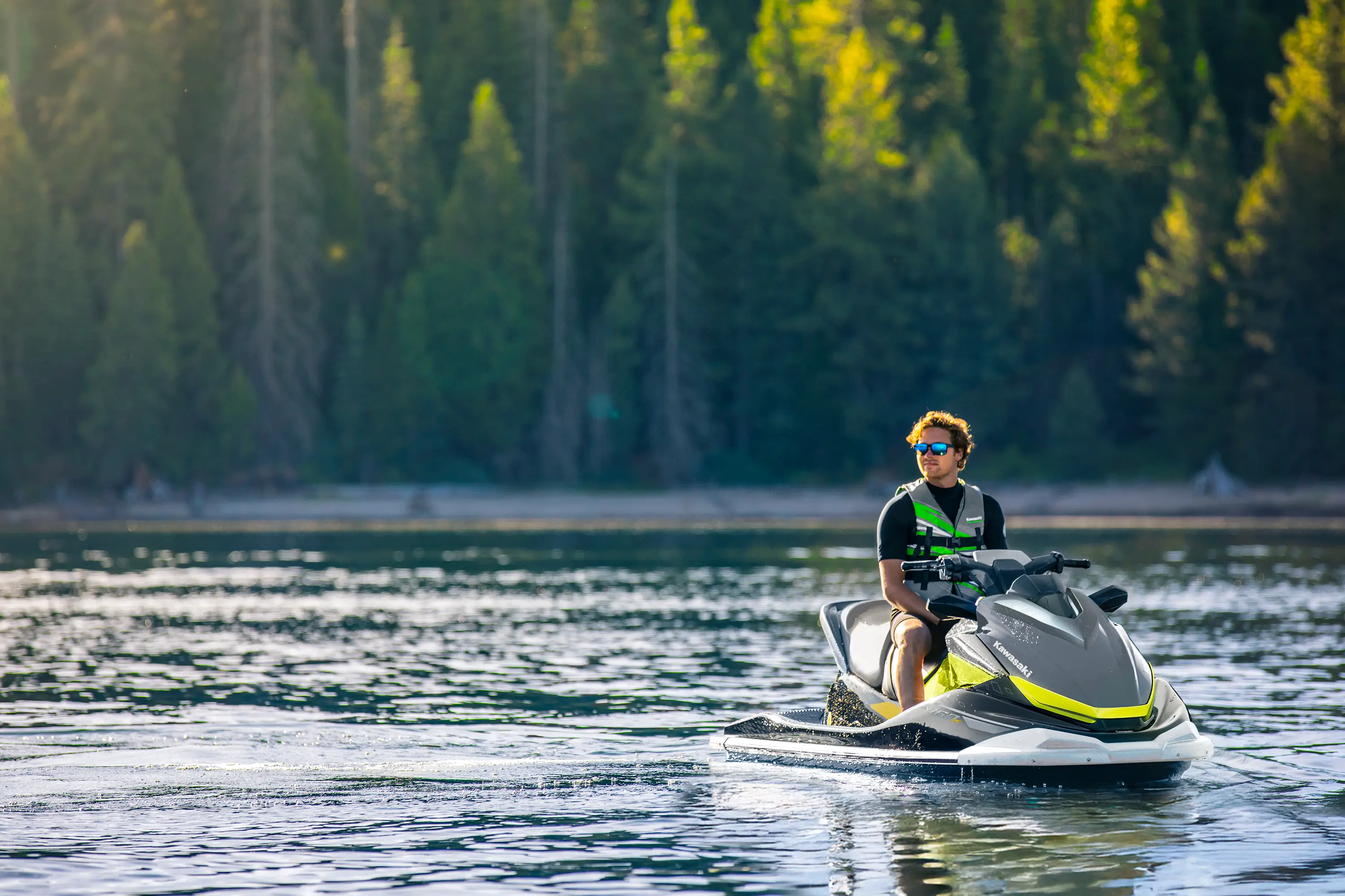 Front angle of a person sitting on a personal watercraft on the water.