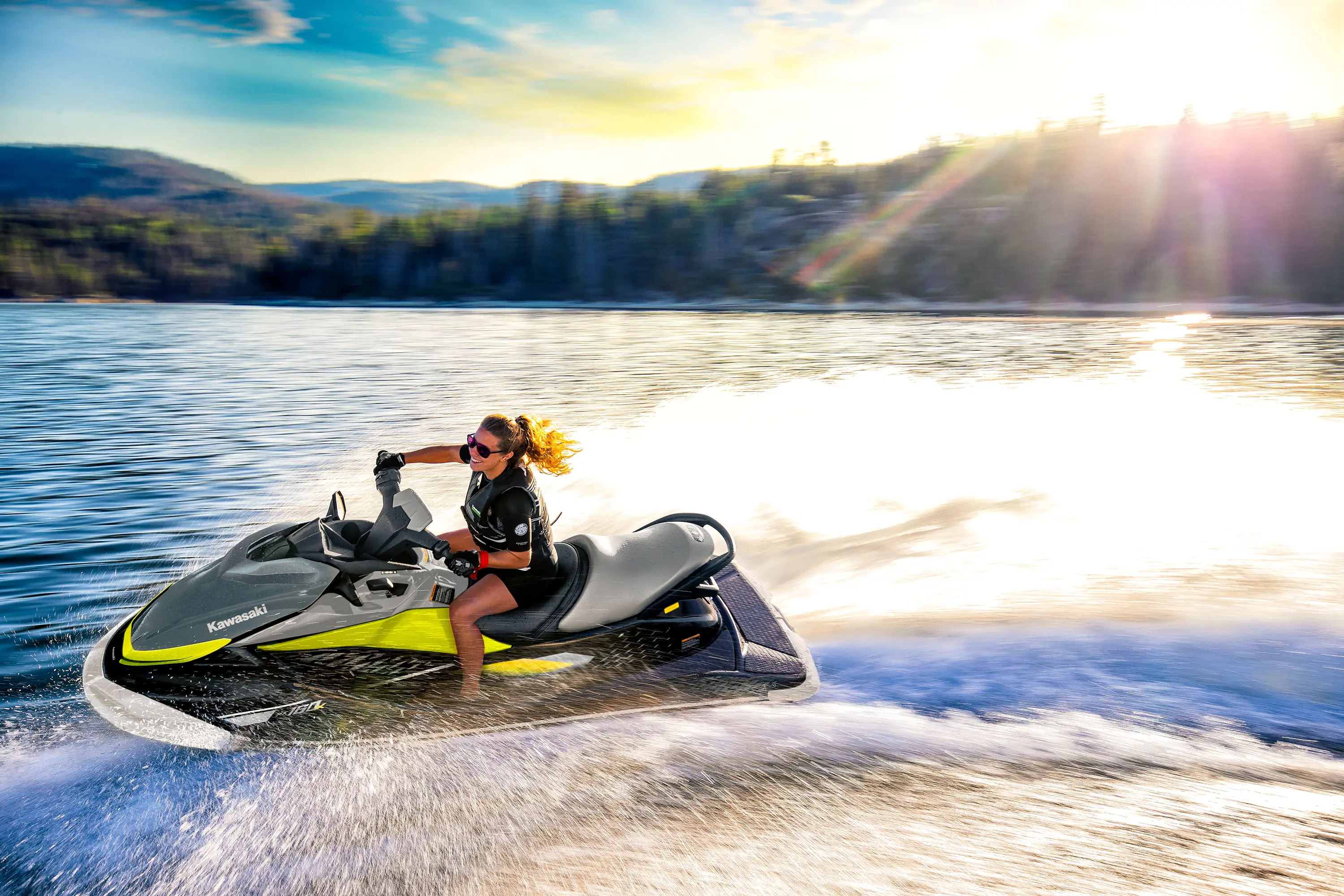 Side angle of a person on a personal watercraft on the water.