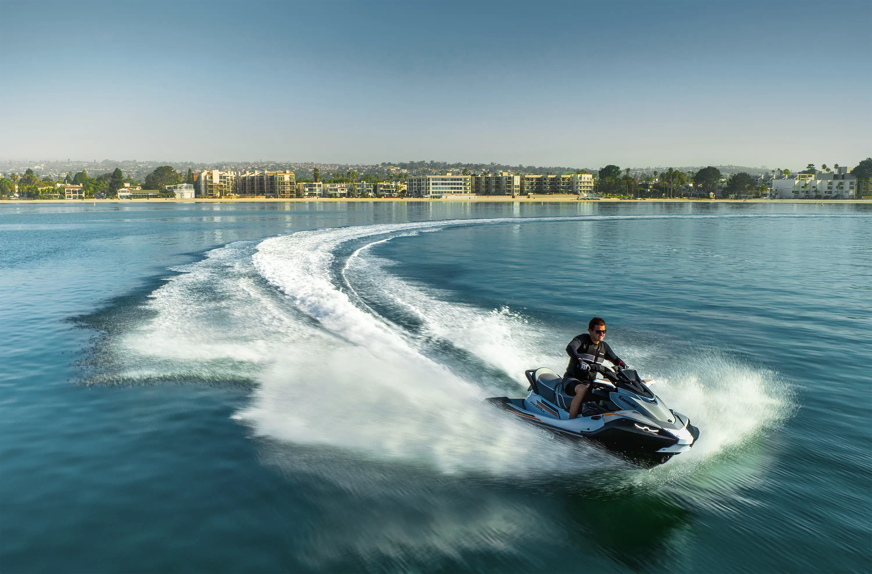 Overhead angle of a person on a personal watercraft on the water.