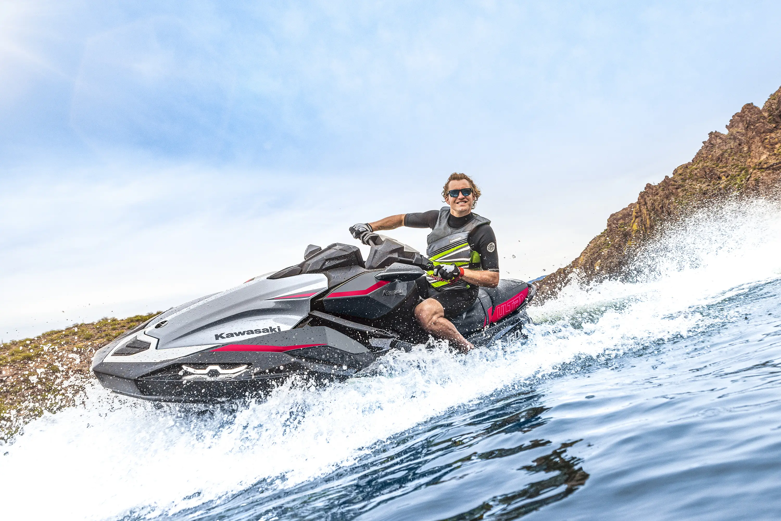 Three-quarter front angle of a person on a personal watercraft on the water.