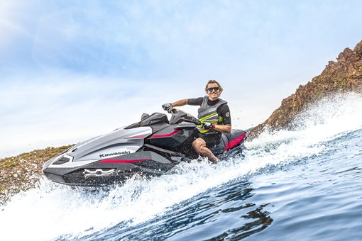 Three-quarter front angle of a person on a personal watercraft on the water. opens in a new window