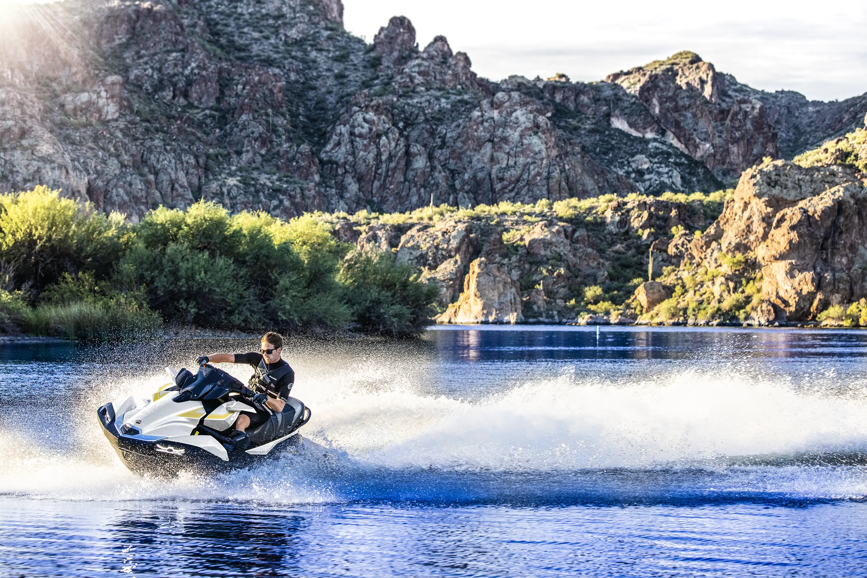 Three-quarter front angle of a person on a personal watercraft on the water.