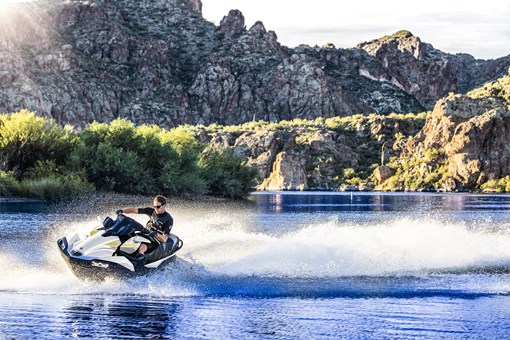 Three-quarter front angle of a person on a personal watercraft on the water. opens in a new window