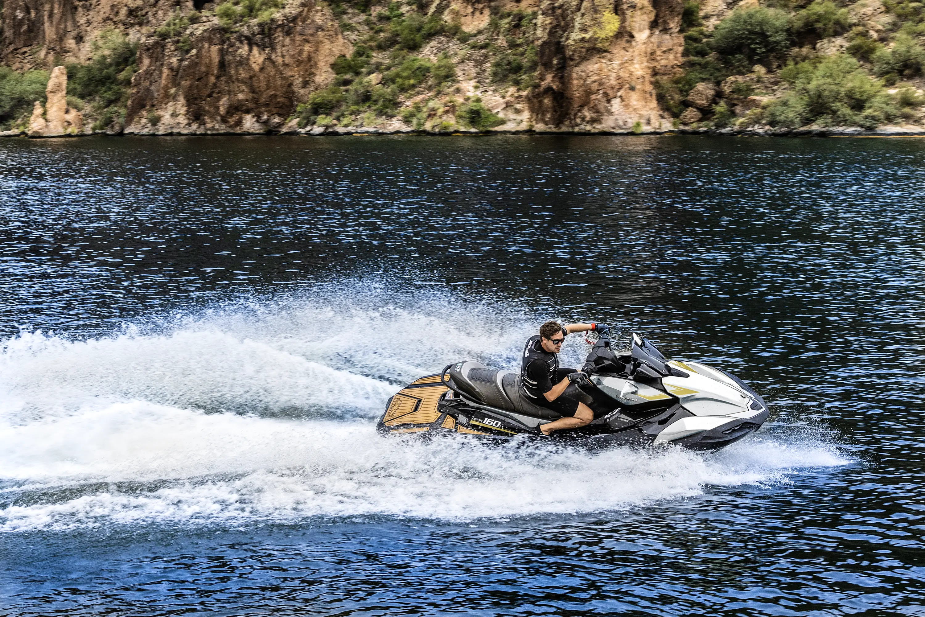 Side angle of a person on a personal watercraft on the water.