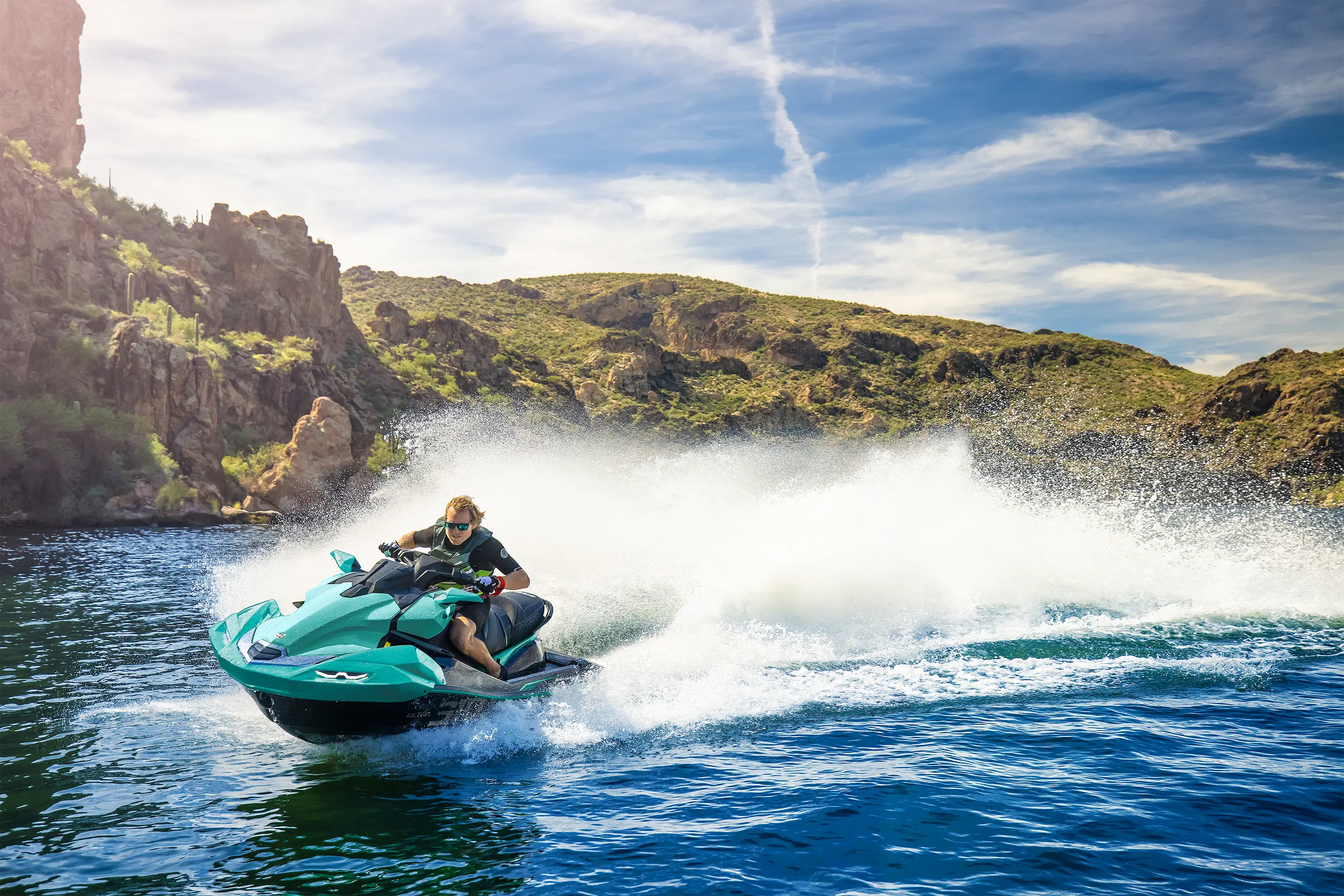 Side angle of a person on a personal watercraft on the water.