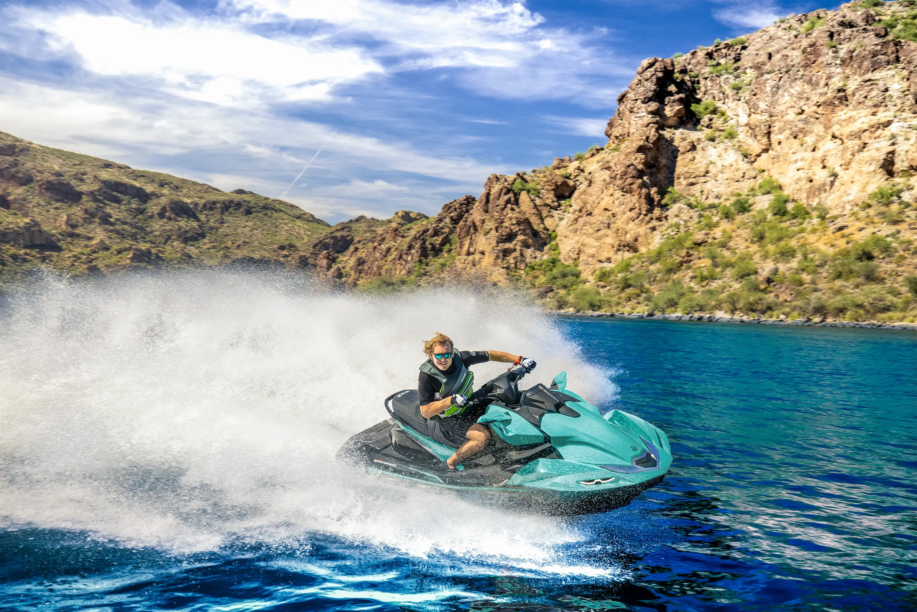 Three-quarter front angle of a person on a personal watercraft on the water.