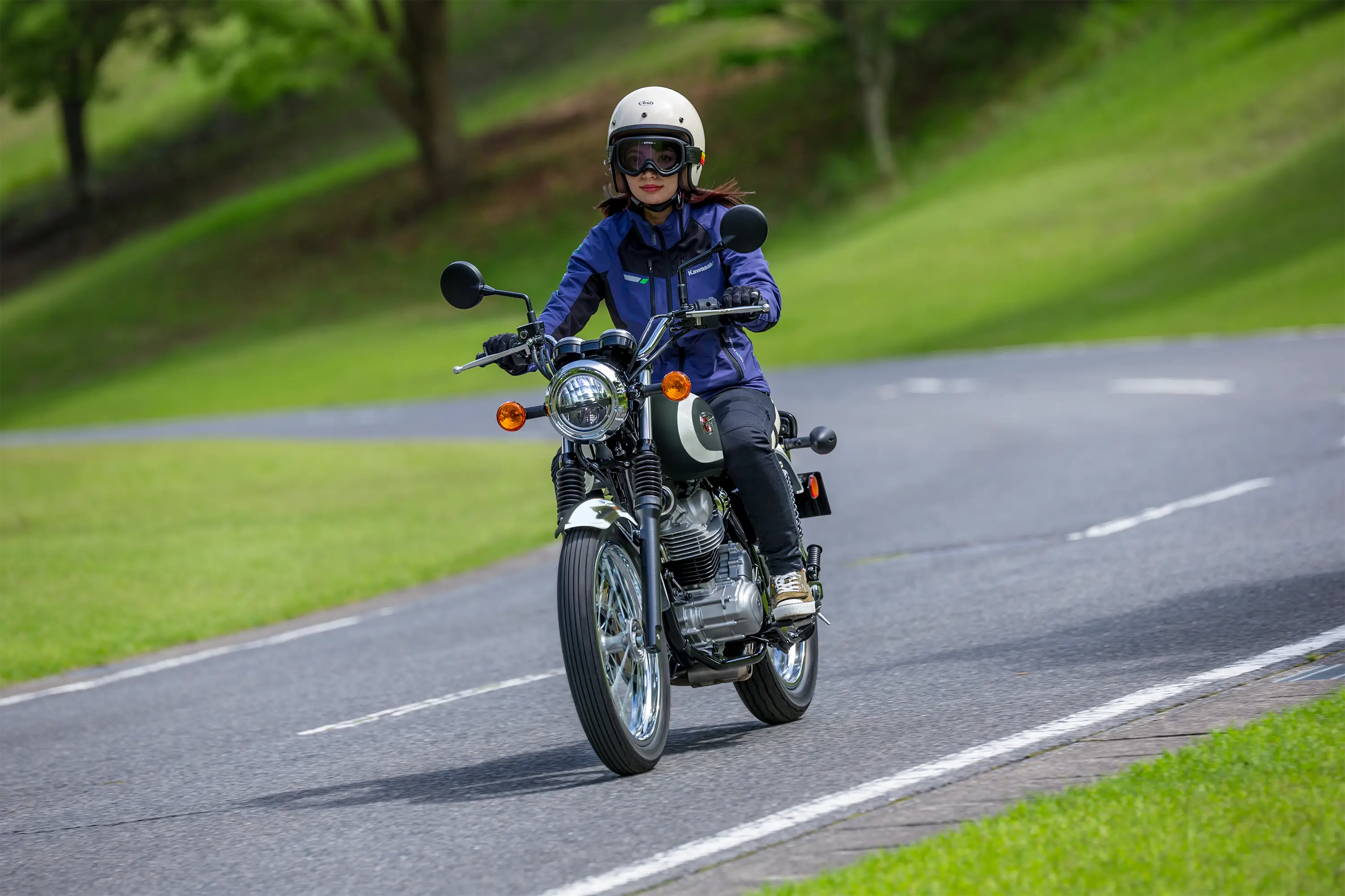 Three-quarter front angle of a person riding a motorcycle on a curvy road.