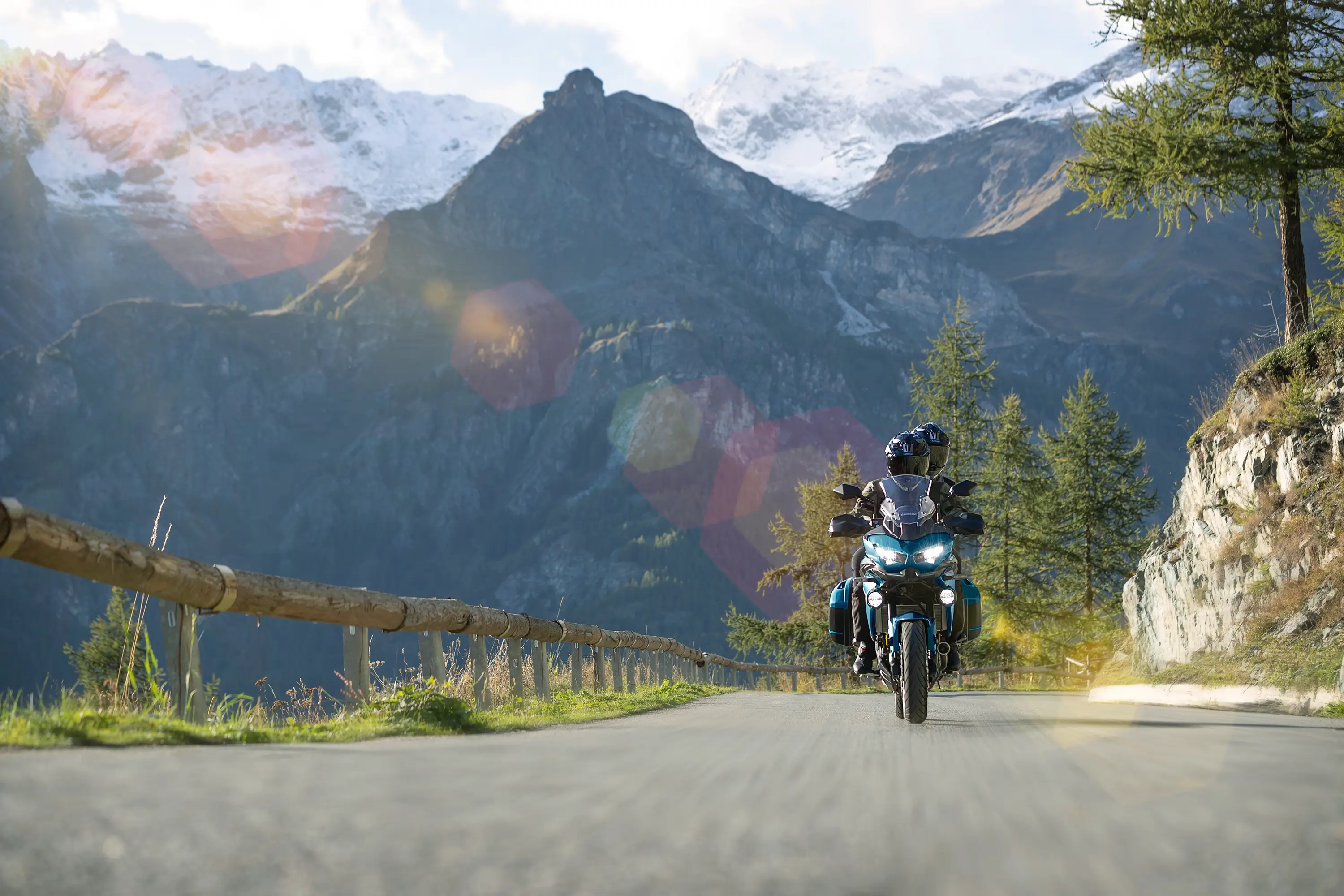 Front angle of a person riding a motorcycle on a mountain highway.