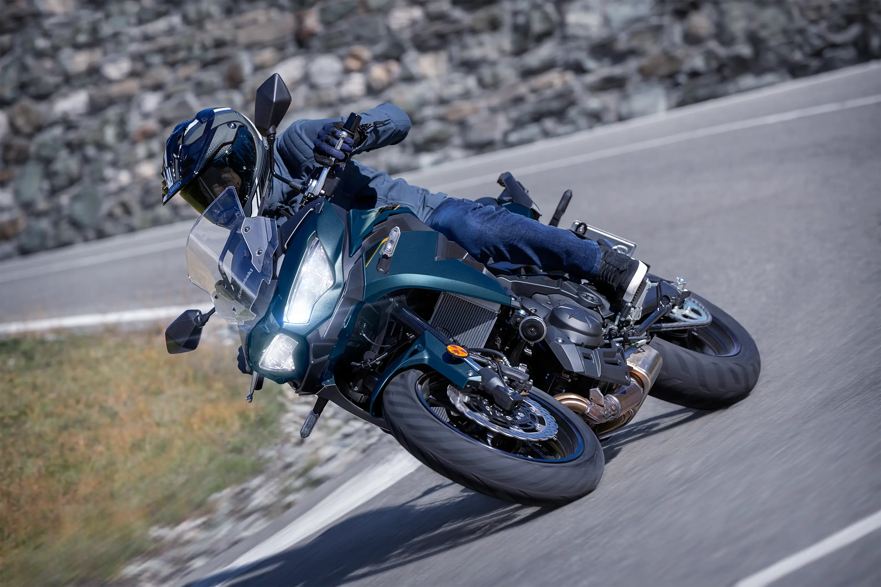 Three-quarter front angle of a person riding a motorcycle on a highway.