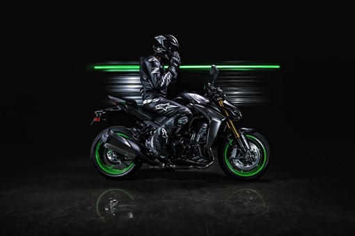 Side angle of a motorcycle parked in a black studio background. opens in a new window