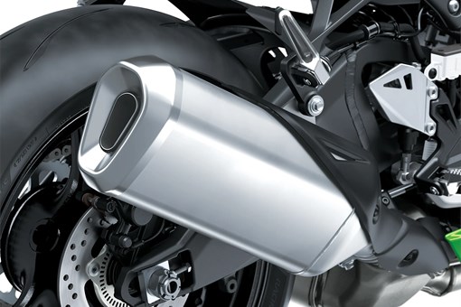 Close-up of the exhaust of a motorcycle staged in a white studio background. opens in a new window