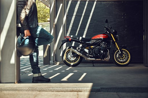 Side angle of a motorcycle parked near a person. opens in a new window