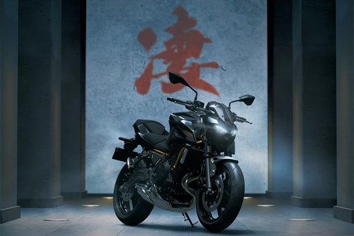 Three-quarter front angle of a motorcycle staged in black studio background. opens in a new window